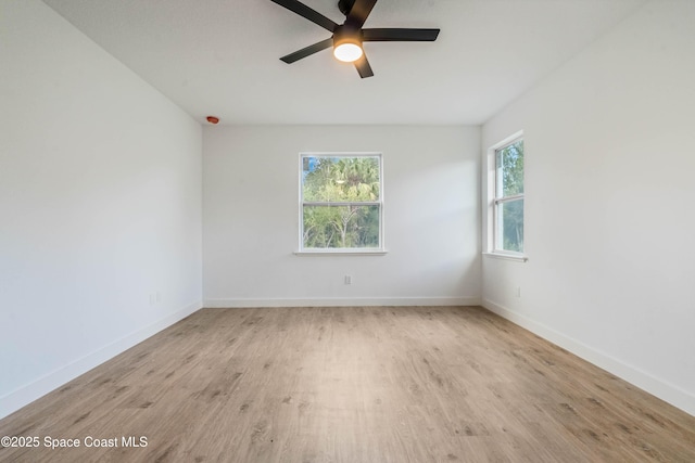 spare room featuring ceiling fan, wood finished floors, and baseboards