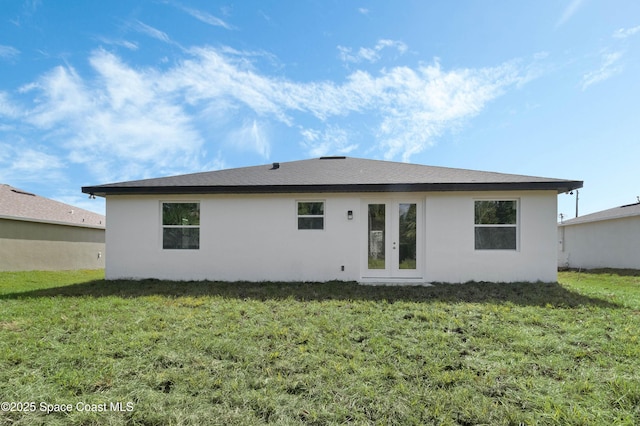 back of house with french doors, a yard, and stucco siding