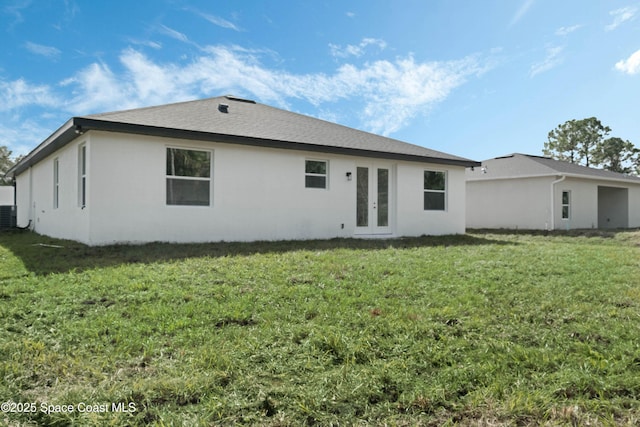 back of property featuring central air condition unit, stucco siding, a lawn, and french doors