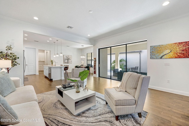 living room with recessed lighting, baseboards, wood finished floors, and ornamental molding