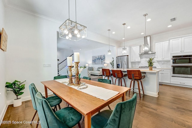 dining space featuring stairway, wood finished floors, visible vents, recessed lighting, and ornamental molding