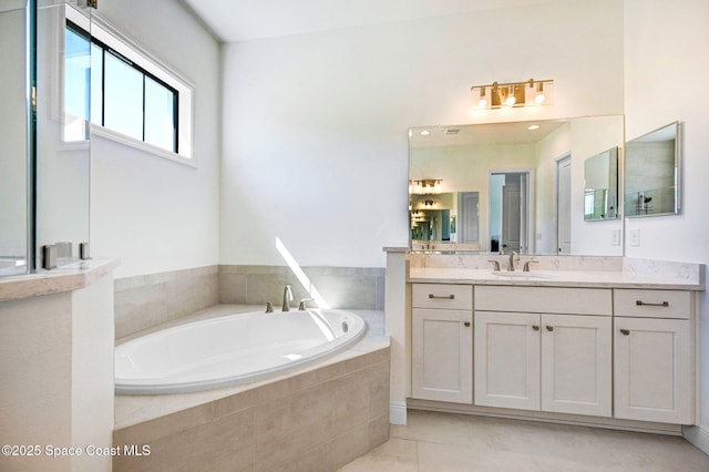 bathroom featuring tile patterned flooring, vanity, and a garden tub
