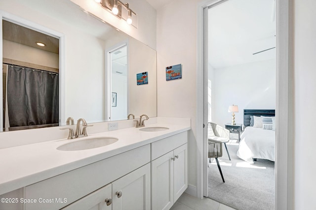 full bathroom with a sink, connected bathroom, double vanity, and tile patterned floors