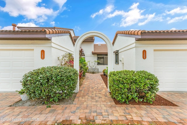 view of front of home featuring a garage, a tile roof, and stucco siding