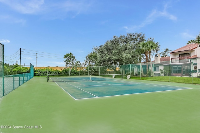 view of tennis court featuring fence