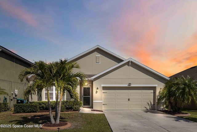 view of front of property featuring stucco siding, driveway, and a garage