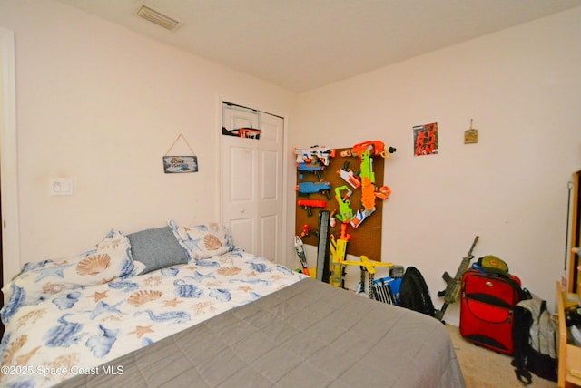 carpeted bedroom featuring a closet and visible vents