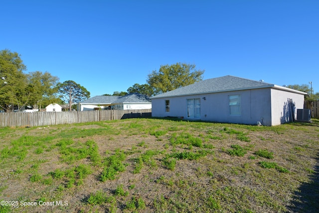 back of house with fence, cooling unit, and stucco siding