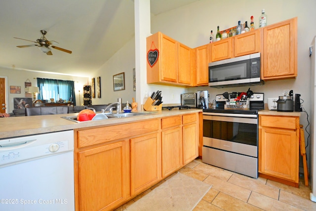 kitchen with ceiling fan, light tile patterned floors, a sink, open floor plan, and appliances with stainless steel finishes