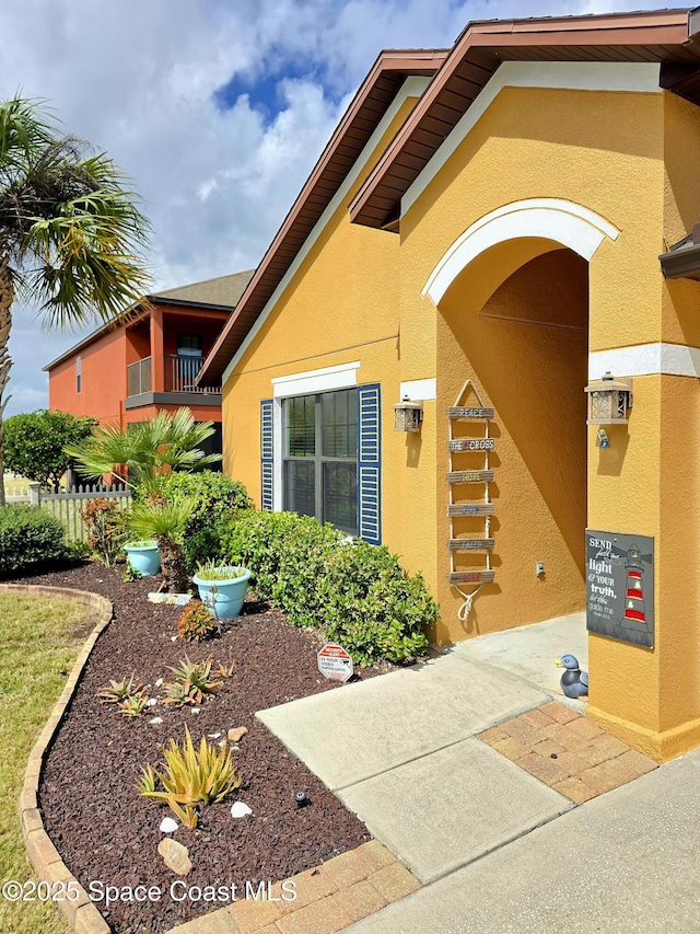 property entrance with fence and stucco siding