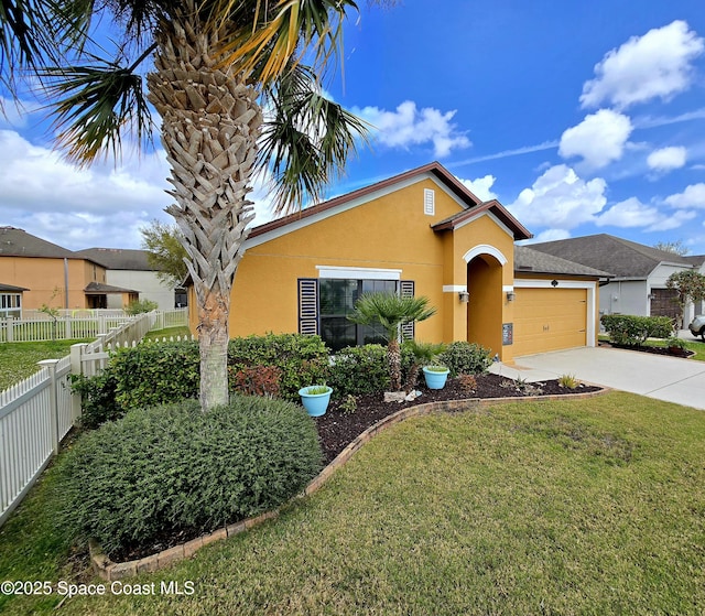 view of front of home featuring stucco siding, a front yard, fence, a garage, and driveway