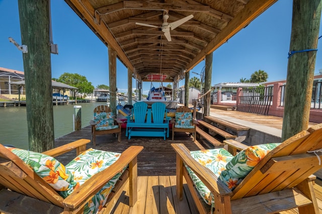 wooden terrace with a water view, a boat dock, and boat lift