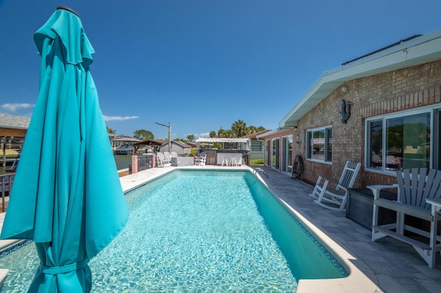 view of swimming pool with a fenced in pool, a patio area, outdoor dry bar, and an outdoor kitchen