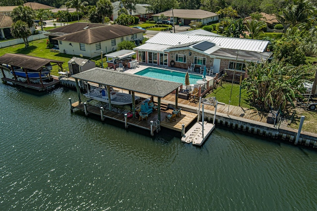 view of dock featuring a patio, a deck with water view, boat lift, and an outdoor pool