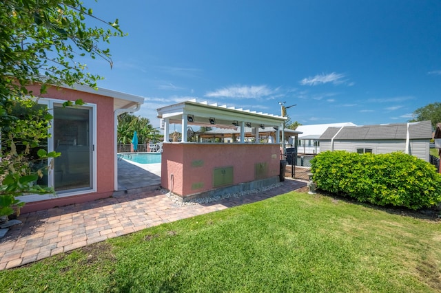 view of yard with fence, an outdoor pool, and an outbuilding