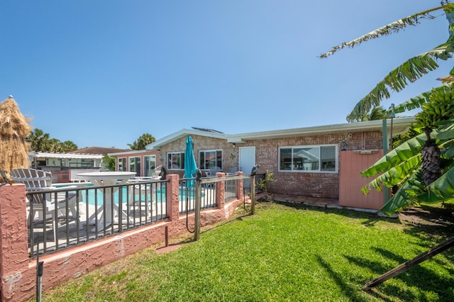 pool featuring a lawn, a patio area, and fence