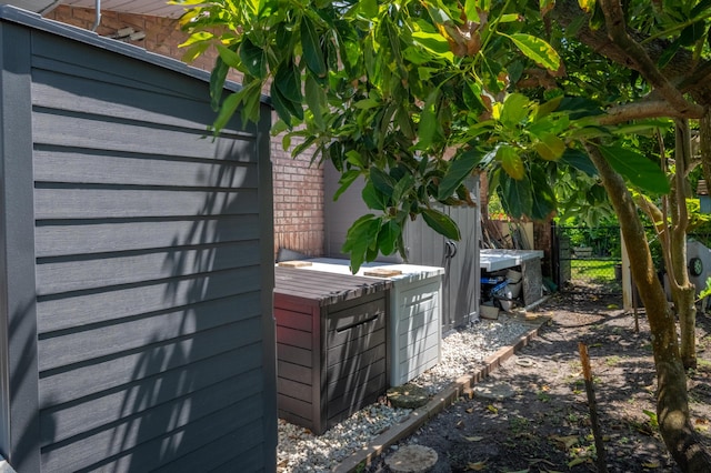 details featuring fence and brick siding