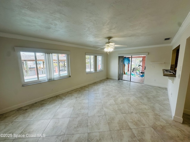 empty room with baseboards, visible vents, a textured ceiling, and ornamental molding