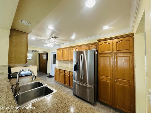 kitchen with ornamental molding, visible vents, a sink, and stainless steel refrigerator with ice dispenser