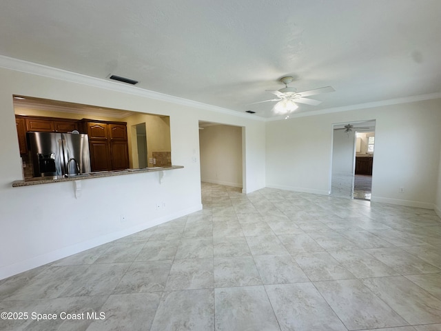 unfurnished living room featuring crown molding, visible vents, ceiling fan, and baseboards