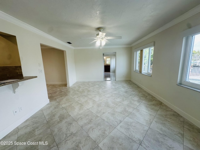 unfurnished room featuring baseboards, visible vents, ornamental molding, and a ceiling fan