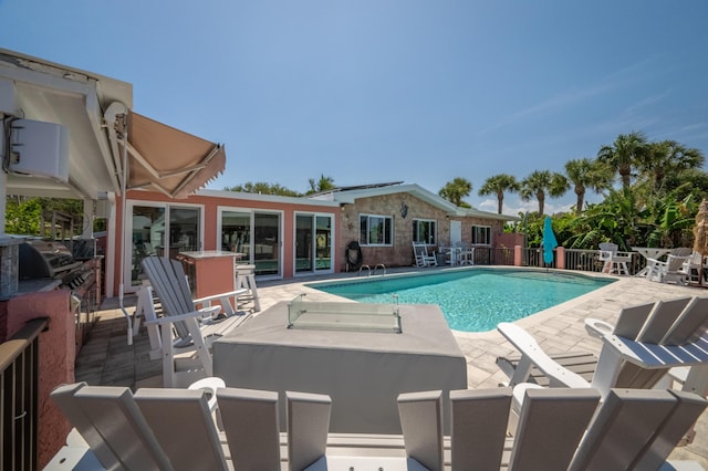 view of swimming pool with a patio area, fence, grilling area, and a fenced in pool