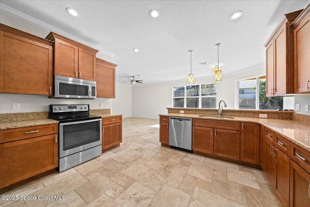 kitchen featuring stone tile floors, brown cabinetry, stainless steel appliances, a sink, and recessed lighting