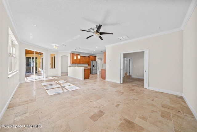 unfurnished living room featuring crown molding, arched walkways, stone tile flooring, and baseboards