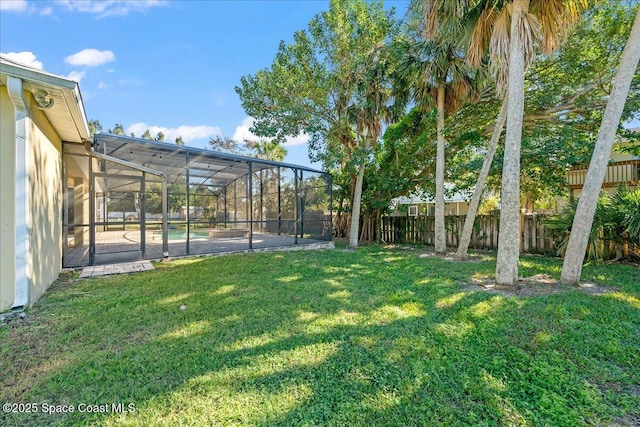 view of yard featuring a fenced in pool, glass enclosure, and a fenced backyard