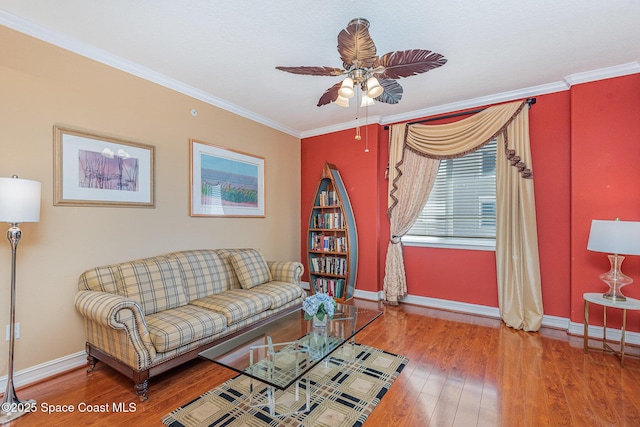 living room featuring ceiling fan, ornamental molding, wood finished floors, and baseboards