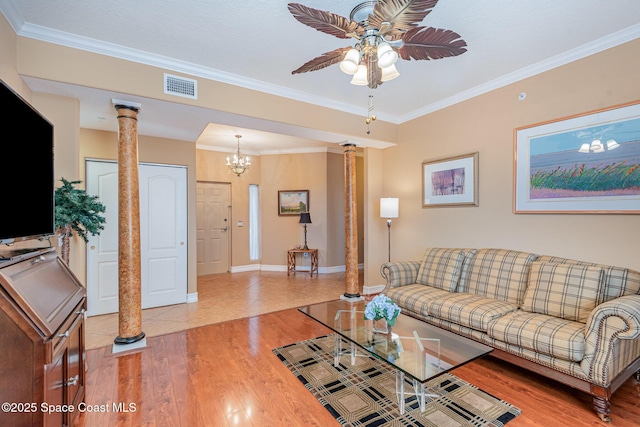 living room with ceiling fan, visible vents, light wood-style floors, ornate columns, and crown molding