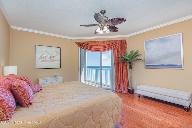 bedroom with access to exterior, crown molding, a textured ceiling, and wood finished floors