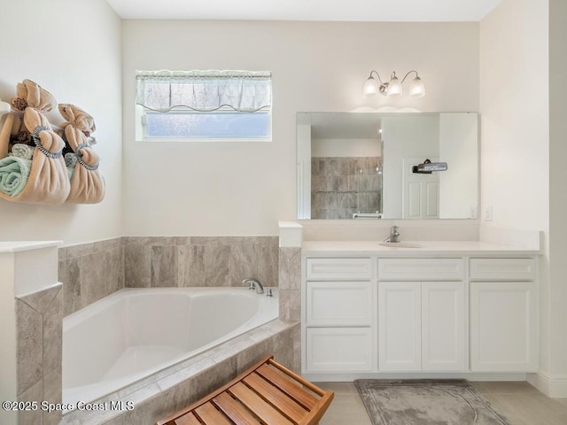 bathroom with tiled shower, a bath, and vanity