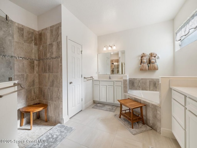 full bath featuring a garden tub, tile patterned floors, a walk in shower, and vanity