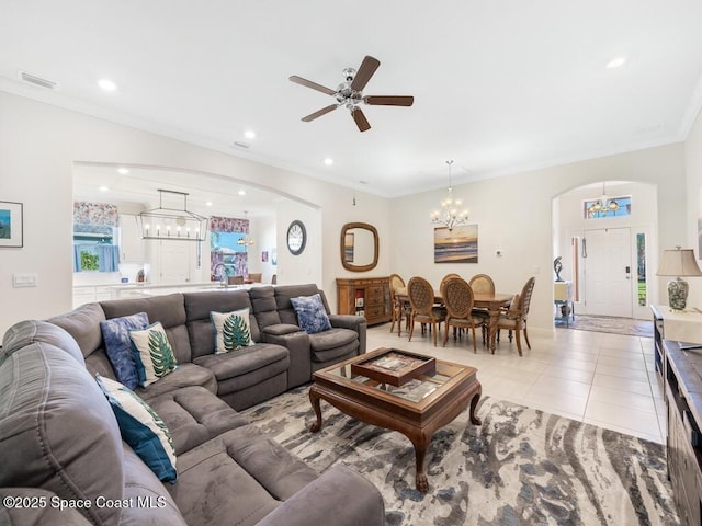 living area with arched walkways, ornamental molding, and light tile patterned flooring