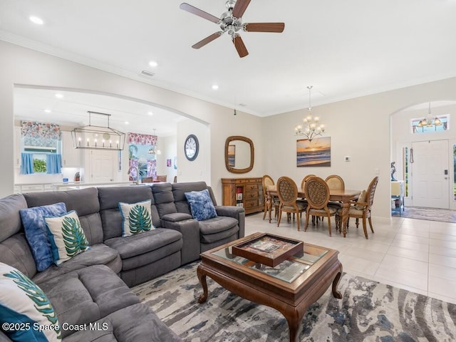 living room with light tile patterned floors, recessed lighting, arched walkways, and ornamental molding