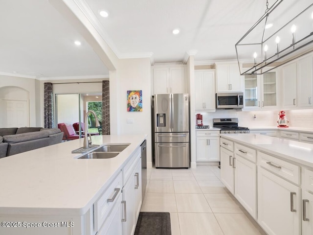 kitchen with crown molding, a kitchen island with sink, stainless steel appliances, and a sink