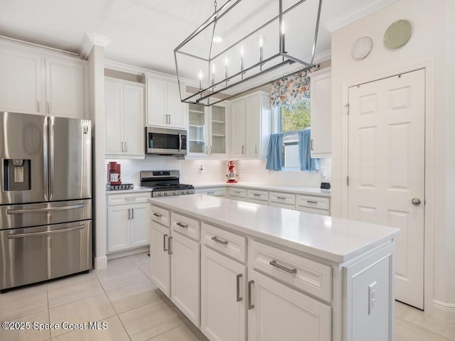 kitchen featuring ornamental molding, appliances with stainless steel finishes, white cabinets, and decorative backsplash