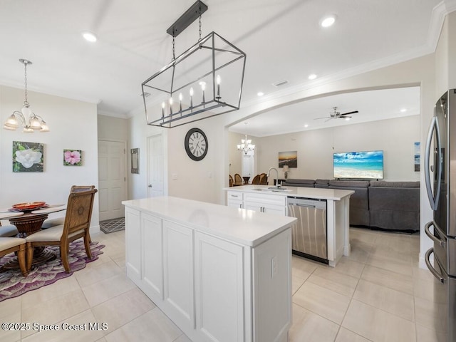 kitchen with arched walkways, a kitchen island with sink, open floor plan, appliances with stainless steel finishes, and crown molding