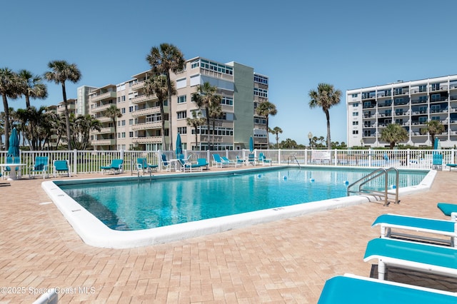 pool with a patio and fence