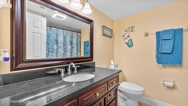 full bath featuring visible vents, a shower with shower curtain, toilet, vanity, and baseboards