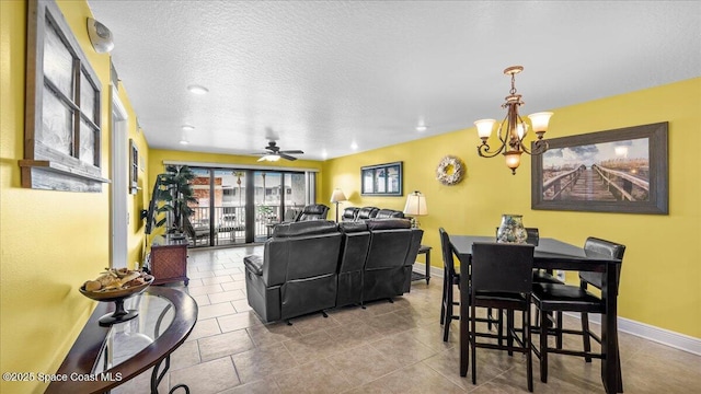 dining room with tile patterned flooring, baseboards, a textured ceiling, and ceiling fan with notable chandelier