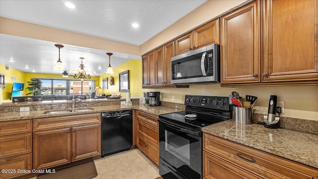 kitchen with light tile patterned floors, brown cabinets, stone counters, black appliances, and a sink