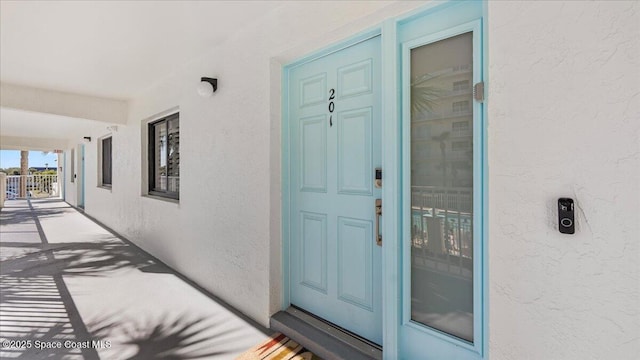 entrance to property featuring stucco siding