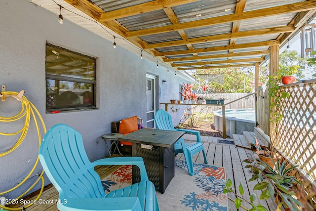 wooden terrace featuring a hot tub and fence