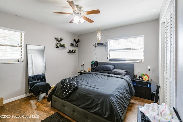 bedroom with a ceiling fan, wood finished floors, and baseboards