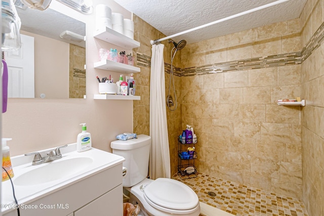 full bath featuring a textured ceiling, a stall shower, vanity, and toilet