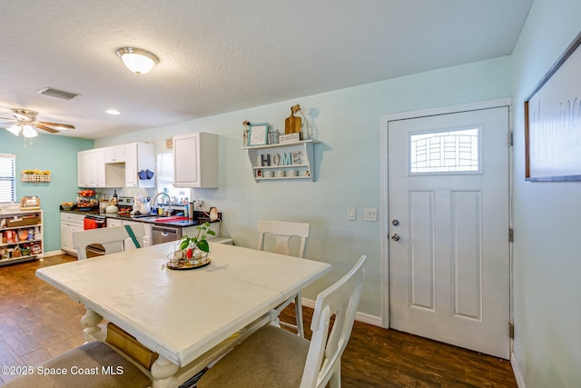 dining space with dark wood-style floors, visible vents, a wealth of natural light, and baseboards