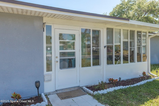 view of exterior entry featuring stucco siding