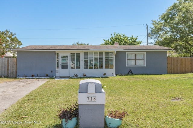 ranch-style home with stucco siding, a front yard, and fence